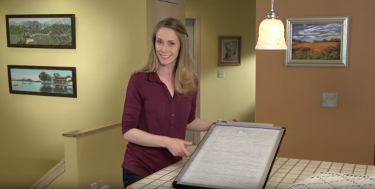 A woman holding a furnace filter