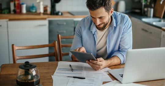 man smiling looking at AC bill