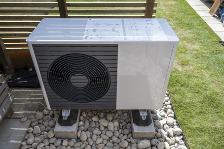 heat pump in a residential yard next to home